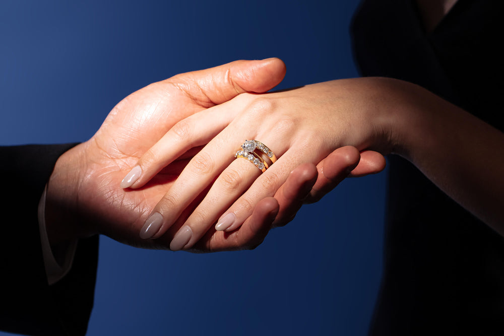 Couple holding hands wearing diamond engagement and wedding rings