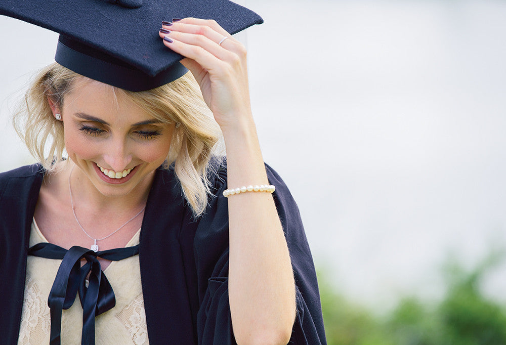 Model wearing jewellery and graduation cap and gown