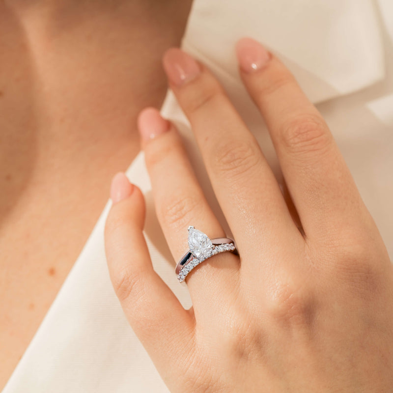 Model wearing Natural Diamond Pear Cut Engagement Ring and Natural Diamond Wedding Ring