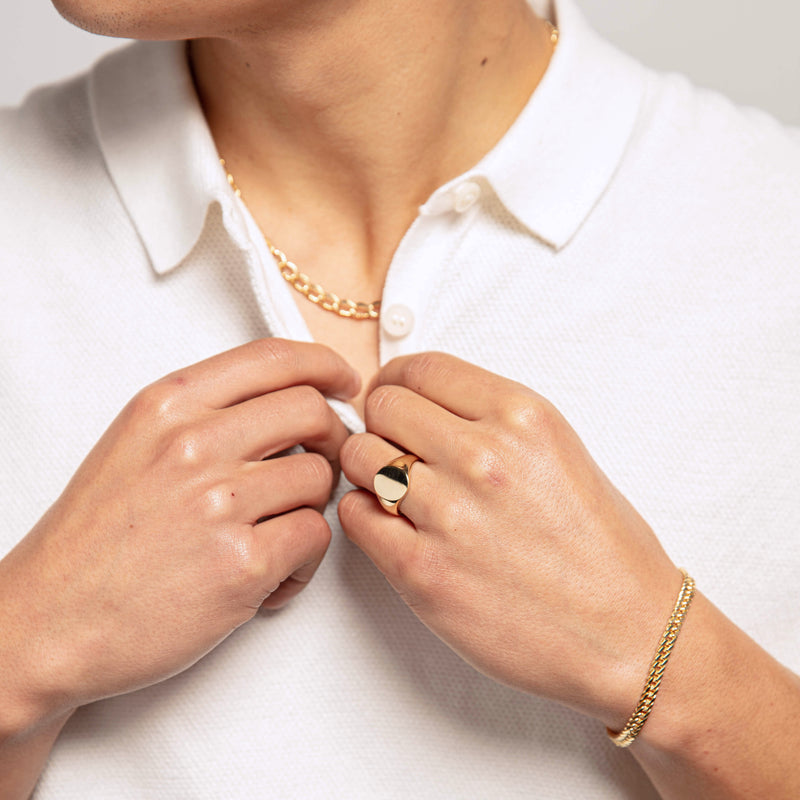 Model wearing gold signet ring and chain
