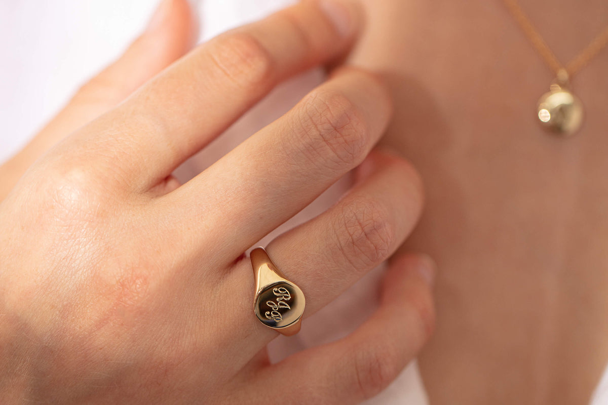 Model wearing engraved signet ring