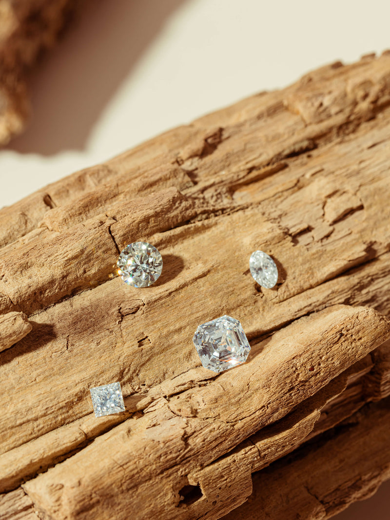 Loose reclaimed diamonds resting on driftwood