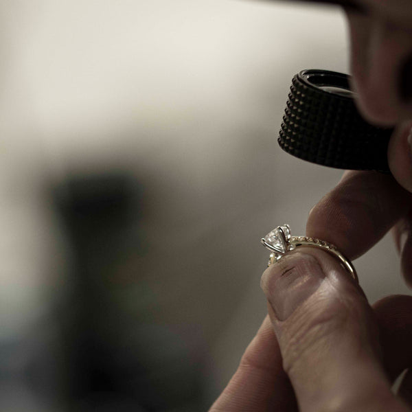Jeweller looking at a diamond ring through a loupe