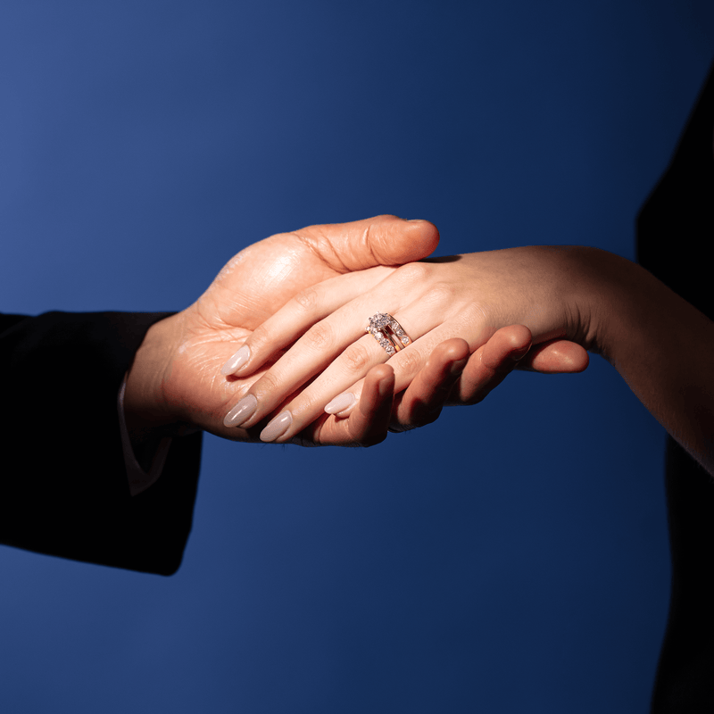 Couple holding hands with model wearing diamond engagement ring