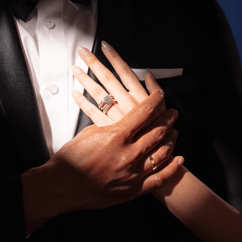 Couple wearing wedding rings with model's hand resting on his chest