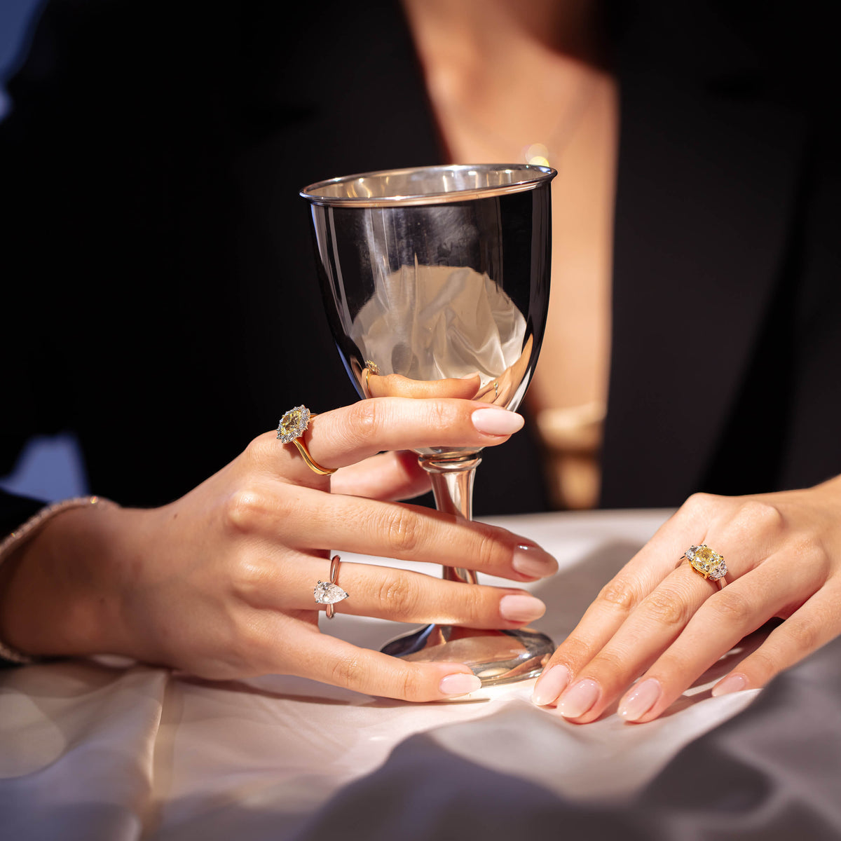 Model holding a sterling silver goblet wearing diamond rings