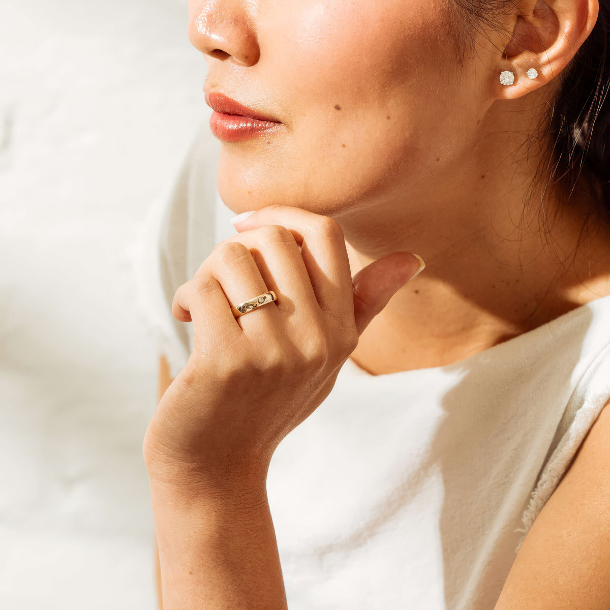 Close up of model wearing yellow gold Milestone Band set with a single white diamond.