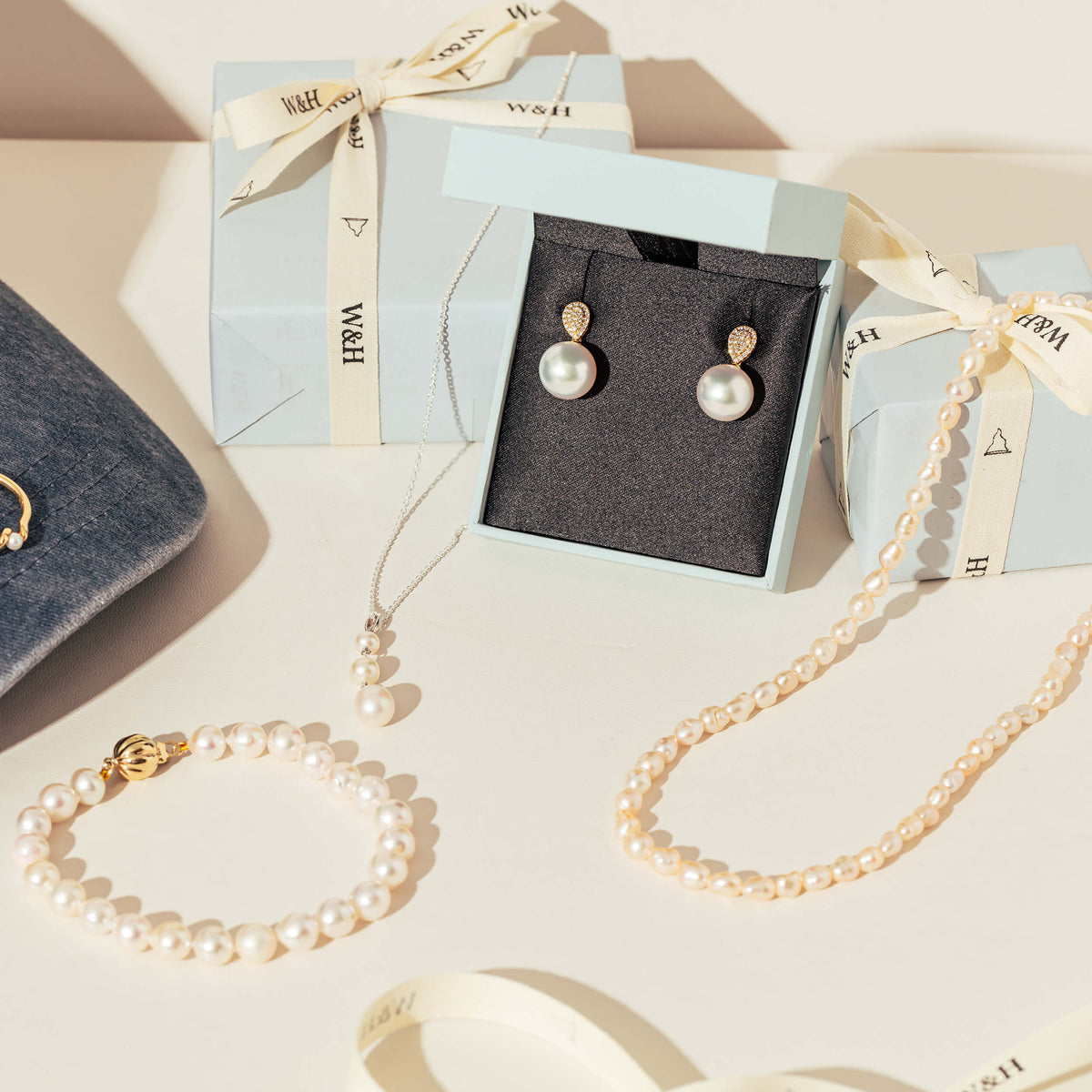 Selection of pearl jewellery with Walker & Hall wrapped gift boxes