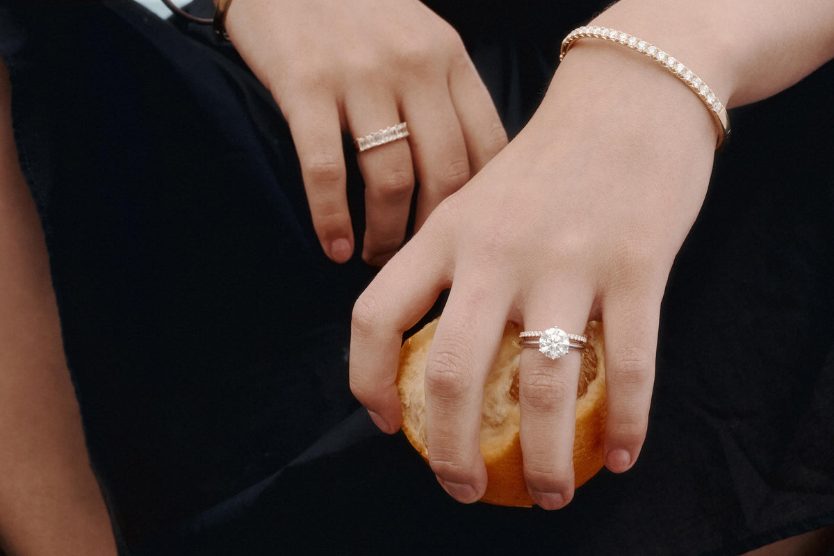 Model wearing natural diamond engagement ring, wedding ring and bracelet