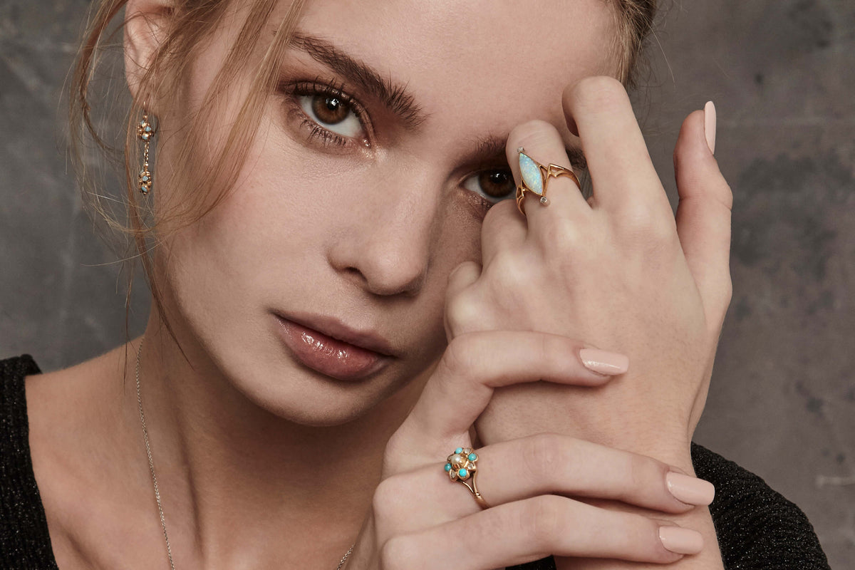 Model wearing Art Nouveau style rings and earrings