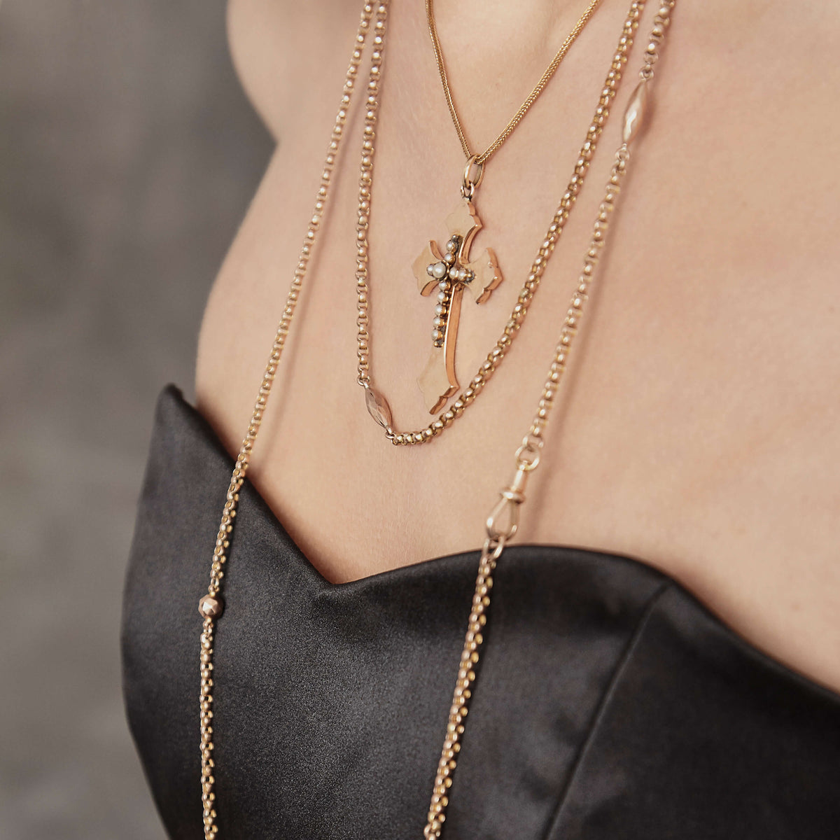 Close up of model wearing Victorian pendant and chains