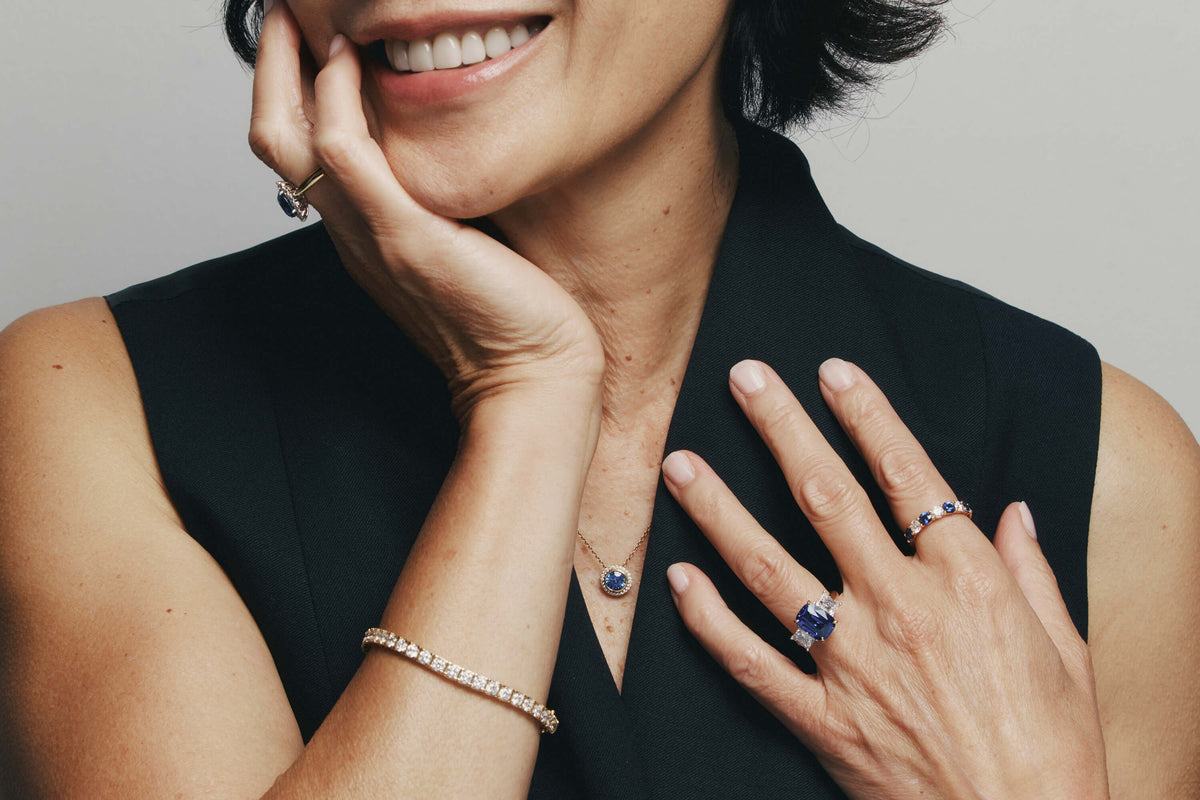 Model wearing diamond and sapphire jewellery including rings, bracelets and necklace