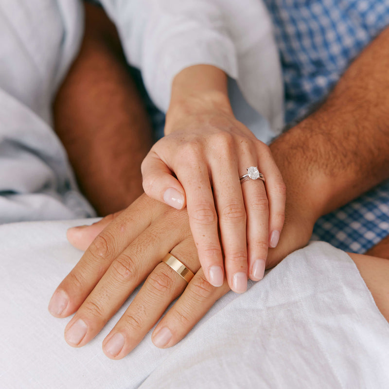 Couple holding hands wearing wedding rings