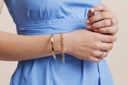 Model wearing yellow gold rings and bracelets