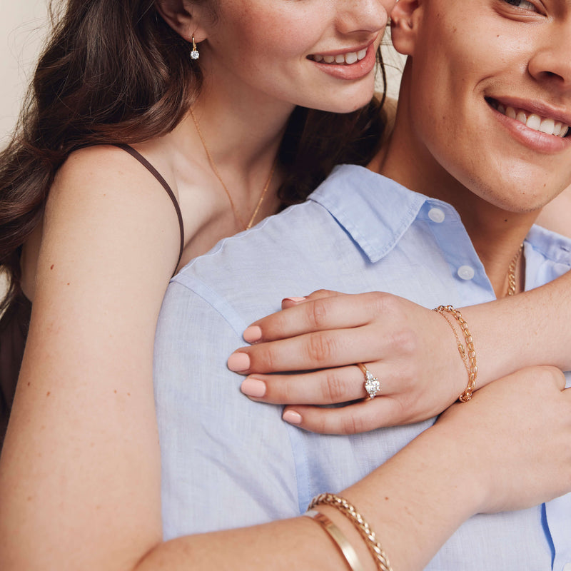 Couple embracing, model wearing diamond engagement ring