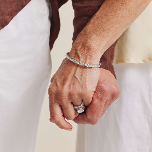 Couple holding hands, model wearing diamond rings and bracelet