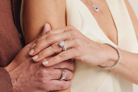 Couple holding hands with woman wearing diamond engagement and weddings rings